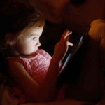 Adorable little girl playing on a tablet